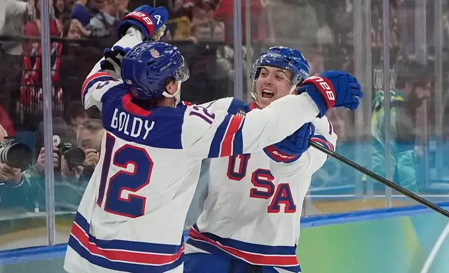 United States' Matt Boldy, left, celebrates after scoring the opening goal during a men's ice hockey gold medal game between Canada and the United States at the 2026 Winter Olympics, in Milan, Italy, Sunday, Feb. 22, 2026. (AP Photo/Hassan Ammar)