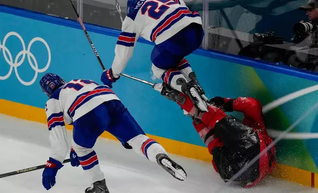 United States' Charlie McAvoy (25) leaps over Canada's Tom Wilson (43) during the second period of the men's ice hockey gold medal game at the 2026 Winter Olympics, in Milan, Italy, Sunday, Feb. 22, 2026. (AP Photo/Luca Bruno)