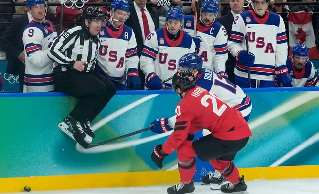 United States' Matt Boldy (12) and Canada's Thomas Harley (20) vie for the puck during the second period of a men's ice hockey gold medal game between Canada and the United States at the 2026 Winter Olympics, in Milan, Italy, Sunday, Feb. 22, 2026. (AP Photo/Petr David Josek)