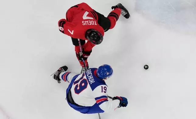 United States' Matthew Tkachuk (19) challenges with Canada's Devon Toews (7) during a men's ice hockey gold medal game between Canada and the United States at the 2026 Winter Olympics, in Milan, Italy, Sunday, Feb. 22, 2026. (AP Photo/Nikos Seimenakis)