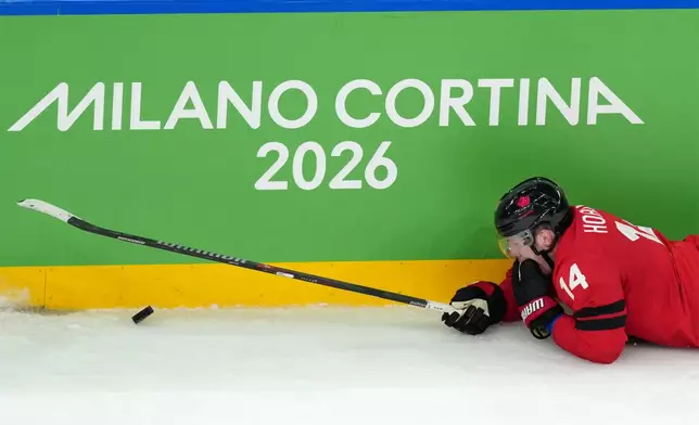 Canada's Bo Horvat falls after being hit with a high stick during the third period of the men's ice hockey gold medal game between Canada and the United States at the 2026 Winter Olympics in Milan, Italy, Sunday, Feb. 22, 2026. (AP Photo/Carolyn Kaster)