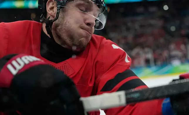 Canada's Bo Horvat (14) crashes into the boards during a men's ice hockey gold medal game between Canada and the United States at the 2026 Winter Olympics, in Milan, Italy, Sunday, Feb. 22, 2026. (AP Photo/Petr David Josek)