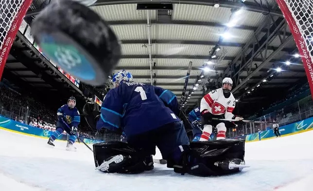 Switzerland's Alina Muller scores her side's opening goal during a preliminary round match of women's ice hockey between Finland and Switzerland at the 2026 Winter Olympics, in Milan, Italy, Tuesday, Feb. 10, 2026. (AP Photo/Darko Bandic, Pool)