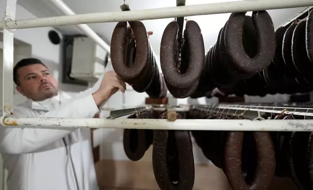 Misa Rajic hangs ironed sausages at his home in Pirot, Serbia, on Feb. 13, 2026. (AP Photo/Darko Vojinovic)