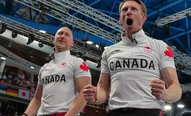 Canada's Brad Jacobs, left, and Marc Kennedy celebrate defeating Britain in a men's curling gold medal match, at the 2026 Winter Olympics, in Cortina d'Ampezzo, Italy, Saturday, Feb. 21, 2026. (AP Photo/Misper Apawu)
