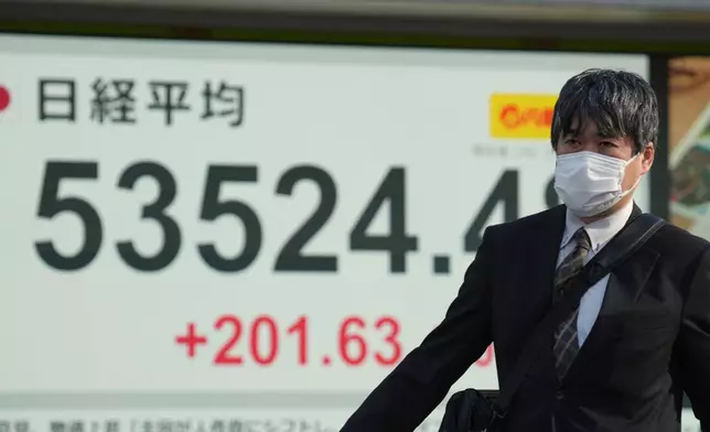 A person walks in front of an electronic stock board showing Japan's Nikkei index at a securities firm Monday, Feb. 2, 2026, in Tokyo. (AP Photo/Eugene Hoshiko)