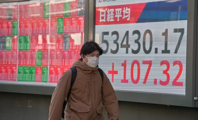 A person walks in front of an electronic stock board showing Japan's Nikkei index at a securities firm Monday, Feb. 2, 2026, in Tokyo. (AP Photo/Eugene Hoshiko)