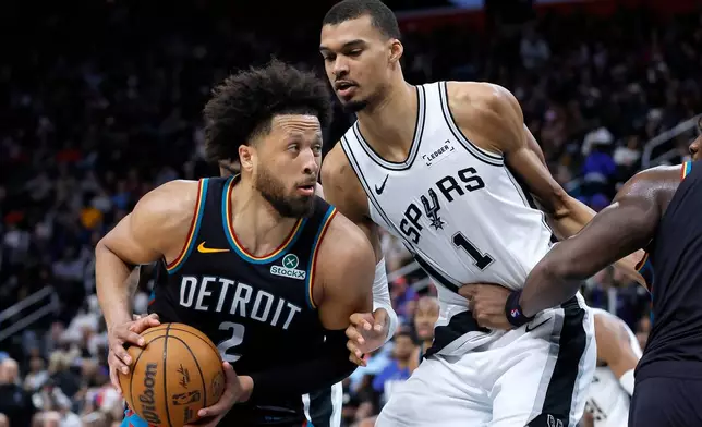 Detroit Pistons guard Cade Cunningham (2) drives against San Antonio Spurs forward Victor Wembanyama (1) during the second half of an NBA basketball game Monday, Feb. 23, 2026, in Detroit. (AP Photo/Duane Burleson)