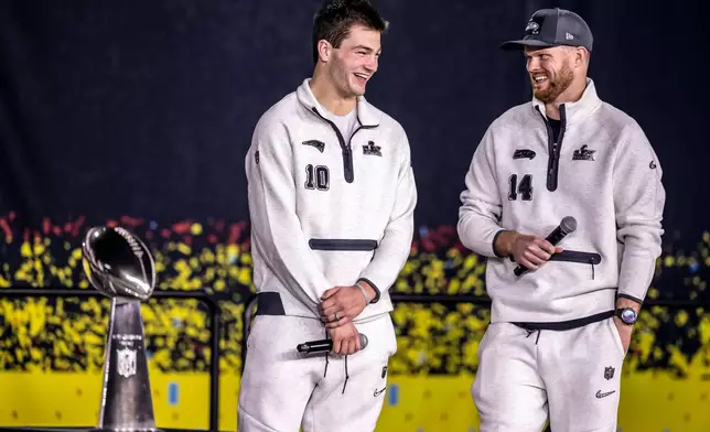 New Englad Patriots quarterback Drake Maye, left, and Seattle Seahawks quarterback Sam Darnold, right, smile on stage with the Lombardi Trophy during the NFL Super Bowl Opening Night, Monday, Feb. 2, 2026, in San Jose, Calif., ahead of the Super Bowl 60 football game between the New England Patriots and the Seattle Seahawks. (Carlos Avila Gonzalez/San Francisco Chronicle via AP)