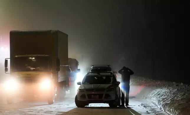 A motorist exits a vehicle during a snow storm Wednesday, Feb. 18, 2026, in Placer County, Calf. (AP Photo/Godofredo A. Vásquez)