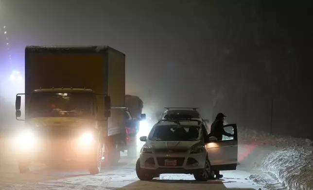 A motorist exits a vehicle during a snow storm Wednesday, Feb. 18, 2026, in Placer County, Calf. (AP Photo/Godofredo A. Vásquez)