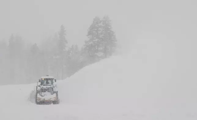 A road is cleared during a snow storm on Wednesday, Feb. 18, 2026 near Soda Springs, Calif. (AP Photo/Brooke Hess-Homeier)