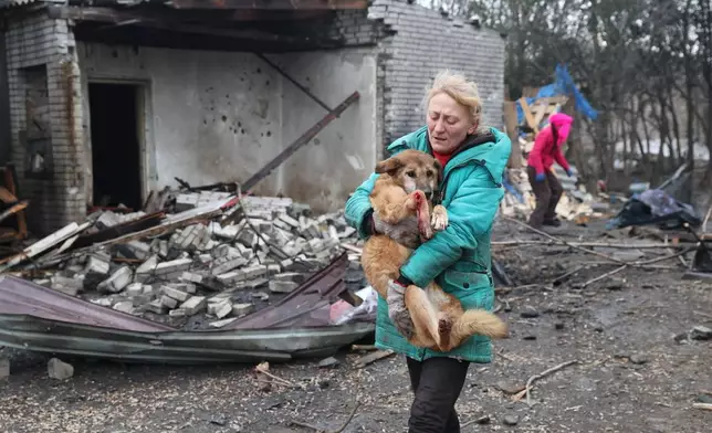 People evacuate wounded dogs after a Russian aerial strike hit a stray dog shelter in Zaporizhzhia, Ukraine, Friday, Feb. 6, 2026. (AP Photo/Kateryna Klochko)