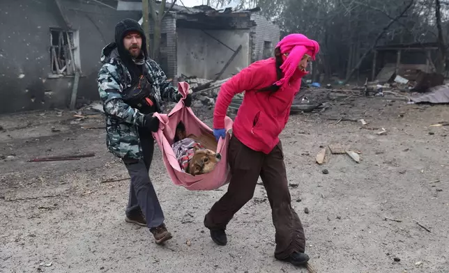 People evacuate wounded dogs after a Russian aerial strike hit a stray dog shelter in Zaporizhzhia, Ukraine, Friday, Feb. 6, 2026. (AP Photo/Kateryna Klochko)