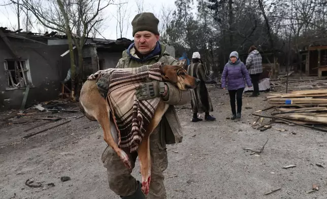 People evacuate wounded dogs after a Russian aerial strike hit a stray dog shelter in Zaporizhzhia, Ukraine, Friday, Feb. 6, 2026. (AP Photo/Kateryna Klochko)