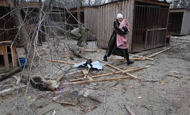 People evacuate wounded dogs after a Russian aerial strike hit a stray dog shelter in Zaporizhzhia, Ukraine, Friday, Feb. 6, 2026. (AP Photo/Kateryna Klochko)