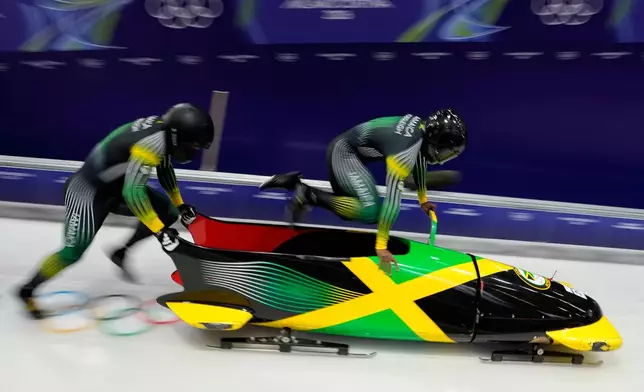 Jamaica's Shane Pitter, right, and Junior Harris start for a two man bobsled run at the 2026 Winter Olympics, in Cortina d'Ampezzo, Italy, Monday, Feb. 16, 2026. (AP Photo/Aijaz Rahi)
