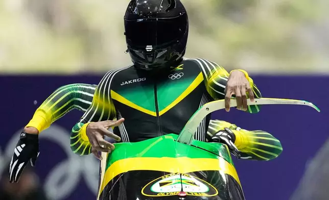 Jamaica's Shane Pitter, front, and Junior Harris start for a two man bobsled run at the 2026 Winter Olympics, in Cortina d'Ampezzo, Italy, Monday, Feb. 16, 2026. (AP Photo/Alessandra Tarantino)