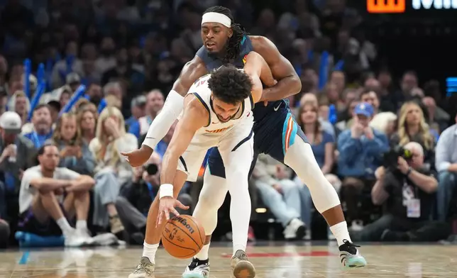 Oklahoma City Thunder guard Luguentz Dort, back, tries to steal the ball from Denver Nuggets guard Jamal Murray during the second half of an NBA basketball game, Friday, Feb. 27, 2026, in Oklahoma City. (AP Photo/Kyle Phillips)