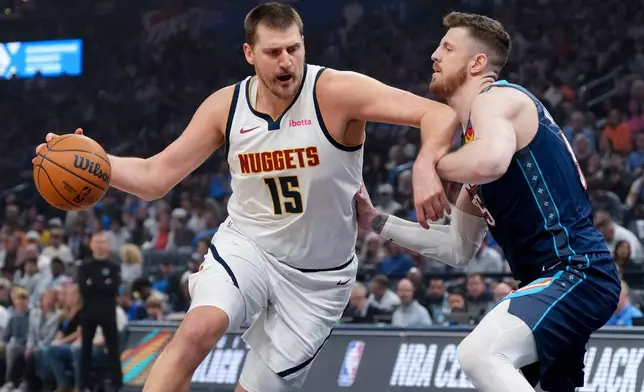Denver Nuggets center Nikola Jokic, left, drives past Oklahoma City Thunder center Isaiah Hartenstein, right, during the first half of an NBA basketball game, Friday, Feb. 27, 2026, in Oklahoma City. (AP Photo/Kyle Phillips)
