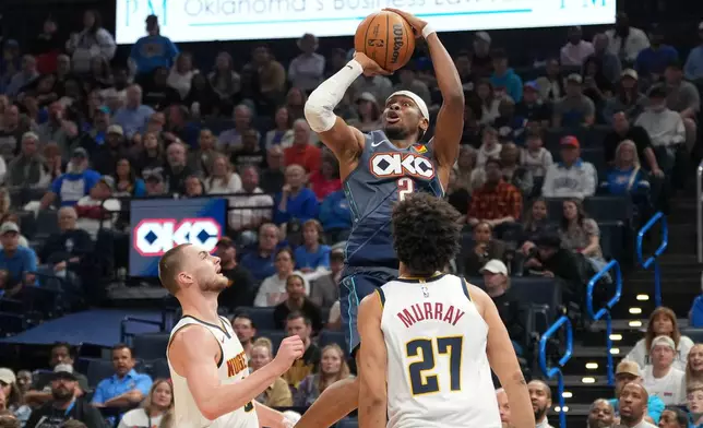 Oklahoma City Thunder guard Shai Gilgeous-Alexander, top, shoots over Denver Nuggets guard Christian Braun, left, and guard Jamal Murray (27) during the second half of an NBA basketball game, Friday, Feb. 27, 2026, in Oklahoma City. (AP Photo/Kyle Phillips)