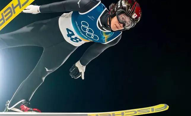 Ren Nikaido, of Japan, soars through the air during his first round jump of the ski jumping men's normal hill individual at the 2026 Winter Olympics, in Predazzo, Italy, Monday, Feb. 9, 2026. (AP Photo/Matthias Schrader)