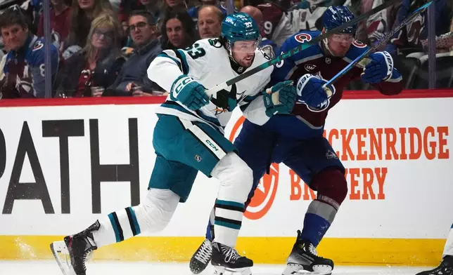 San Jose Sharks center Zack Ostapchuk, left, checks Colorado Avalanche right wing Valeri Nichushkin in the first period of an NHL hockey game, Wednesday, Feb. 4, 2026, in Denver. (AP Photo/David Zalubowski)