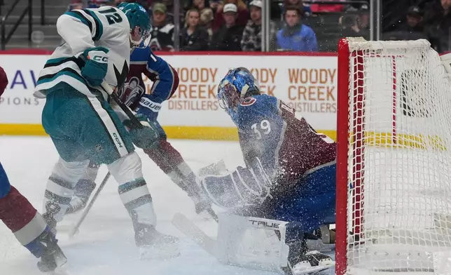 San Jose Sharks left wing William Eklund, left, puts a shot on Colorado Avalanche goaltender MacKenzie Blackwood in the second period of an NHL hockey game Wednesday, Feb. 4, 2026, in Denver. (AP Photo/David Zalubowski)
