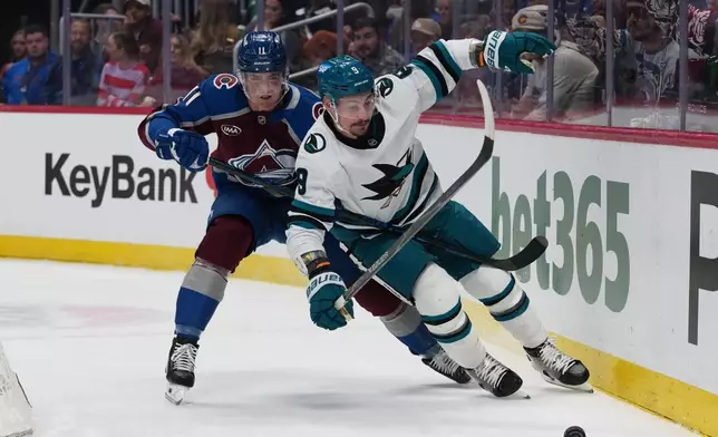 San Jose Sharks defenseman Dmitry Orlov, front, pursues the puck with Colorado Avalanche center Brock Nelson in the first period of an NHL hockey game, Wednesday, Feb. 4, 2026, in Denver. (AP Photo/David Zalubowski)