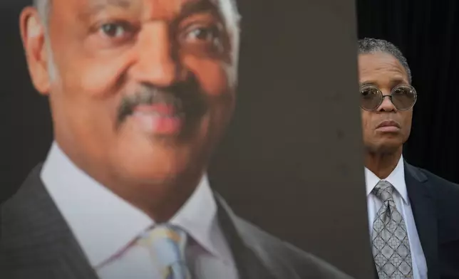Jesse Jackson, Jr. stands near a picture of his father, the late Rev. Jesse Jackson, during a news conference outside the family home in Chicago, Wednesday, Feb. 18, 2026. (AP Photo/Erin Hooley)