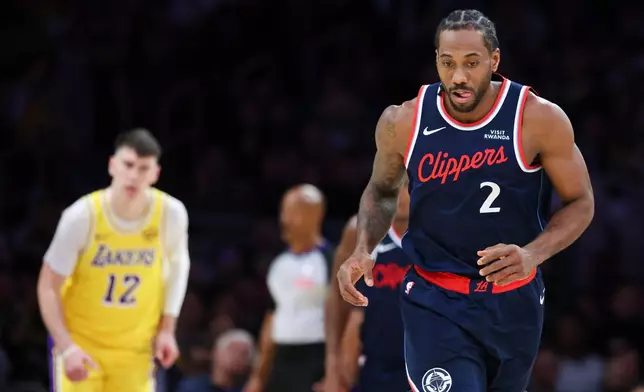 Los Angeles Clippers forward Kawhi Leonard (2) reacts after scoring as Los Angeles Lakers forward Jake LaRavia (12) watches during the first half of an NBA basketball game, Friday, Feb. 20, 2026, in Los Angeles. (AP Photo/Jessie Alcheh)