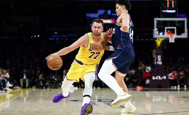 Los Angeles Lakers guard Luka Doncic (77) drives against Los Angeles Clippers center Yanic Konan Niederhauser during the first half of an NBA basketball game, Friday, Feb. 20, 2026, in Los Angeles. (AP Photo/Jessie Alcheh)