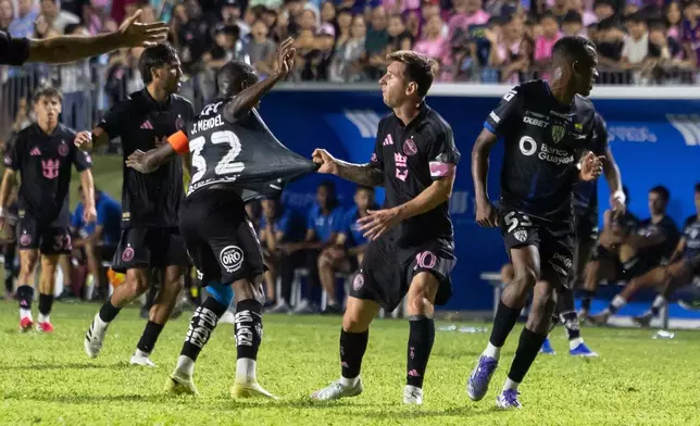 Inter Miami's Lionel Messi grabs the jersey of Jhegson Méndez of Ecuador's Independiente del Valle during an international friendly soccer match in Bayamon, Puerto Rico, Thursday, Feb. 26, 2026. (AP Photo/Alejandro Granadillo)