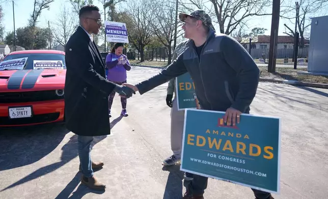 Texas Congressional Candidate Christian D. Menefee shakes hands with Patrick Edge, a poll worker for Amanda Edwards, as he visited a polling location at Acres Homes MultiService Center on Election Day, in Houston, Saturday, Jan. 31, 2026. (AP Photo/ Karen Warren)