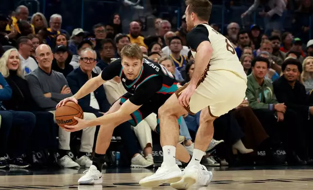 Memphis Grizzlies guard Cam Spencer, left, is defended by Golden State Warriors guard Pat Spencer, right, during the first half of an NBA basketball game in San Francisco, Monday, Feb. 9, 2026. (AP Photo/Jed Jacobsohn)