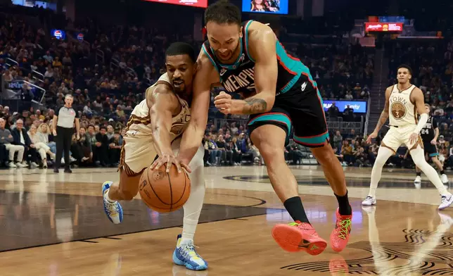Memphis Grizzlies forward Kyle Anderson, right, and Golden State Warriors guard De'anthony Melton, left, reach for a loose ball during the first half of an NBA basketball game in San Francisco, Monday, Feb. 9, 2026. (AP Photo/Jed Jacobsohn)