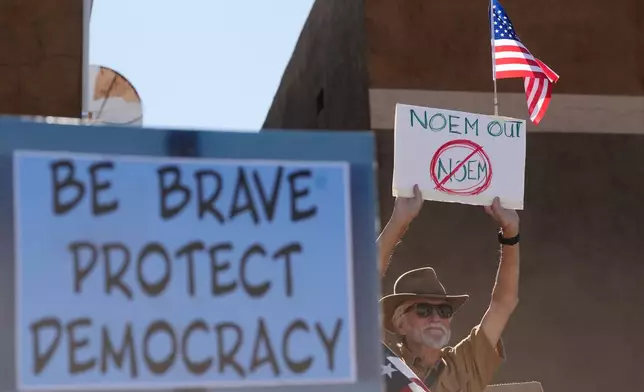 People gather during a protest against immigration enforcement operations after Kristi Noem, Secretary of the Department of Homeland Security, spoke at the border Wednesday, Feb. 4, 2026, in Nogales, Ariz. (AP Photo/Ross D. Franklin)