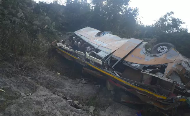 The wreckage of a bus is seen on the bank of the Trishuli River after it drove off a mountain highway near Benighat, west of the capital, Kathmandu, Nepal, Monday, Feb. 23, 2026. (AP Photo/Bijay Rai)