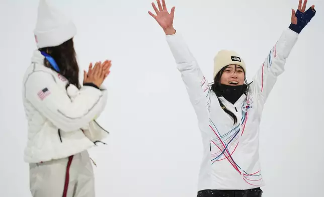 Silver medalist United States' Chloe Kim, left, claps as gold medalist South Korea's Choi Ga-on celebrates winning the the women's snowboarding halfpipe finals at the 2026 Winter Olympics, in Livigno, Italy, Thursday, Feb. 12, 2026. (AP Photo/Abbie Parr)