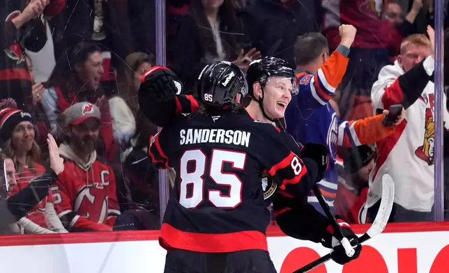 Ottawa Senators' Brady Tkachuk (7) celebrates his goal against the New Jersey Devils with Jake Sanderson (85) during the first period of an NHL hockey game in Ottawa, on Saturday, Jan. 31, 2026. (Justin Tang/The Canadian Press via AP)
