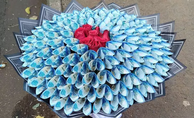 A flower bouquet that incorporates real money sits for sale on the sidewalk in Nairobi, Kenya, Wednesday, Nov. 26, 2025. (AP Photo/Duke Monari)