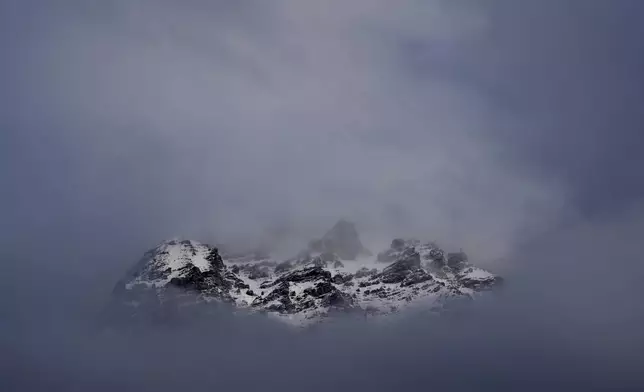 The peaks towards the Stelvio Pass are seen through the clouds ahead of of an alpine ski, men's super-G race, at the 2026 Winter Olympics, in Bormio, Italy, Wednesday, Feb. 11, 2026. (AP Photo/Rebecca Blackwell)