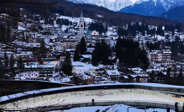 Canada's Beattie Podulsky, left, and Kailey Allan, right, slide down the track during a women's doubles luge run at the 2026 Winter Olympics, in Cortina d'Ampezzo, Italy, Wednesday, Feb. 11, 2026. (AP Photo/Alessandra Tarantino)