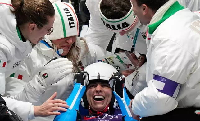 Italy's gold medalists Andrea Voetter and Marion Oberhofer celebrate as they arrive at the finish during a women's doubles luge run at the 2026 Winter Olympics, in Cortina d'Ampezzo, Italy, Wednesday, Feb. 11, 2026. (AP Photo/Aijaz Rahi)