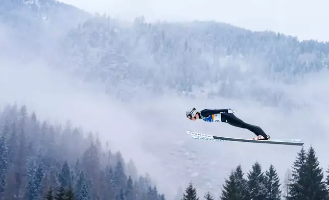 Marco Heinis, of France, soars through the air during the Nordic Combined Individual Gundersen Normal Hill/10km competition at the 2026 Winter Olympics, in Predazzo, Italy, Wednesday, Feb. 11, 2026. (AP Photo/Kirsty Wigglesworth)