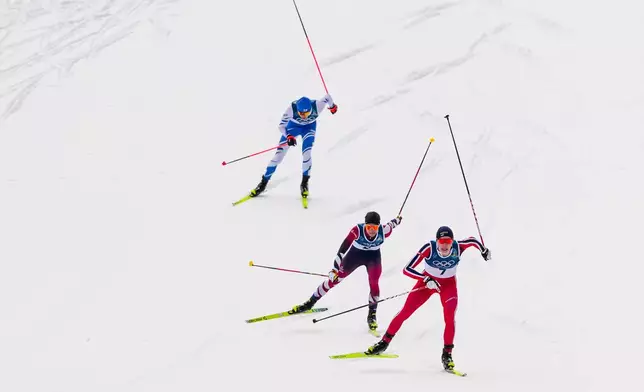 Jens Luraas Oftebro, of Norway, from right, Johannes Lamparter, of Austria and Eero Hirvonen, of Finland, approach the finish line in the Nordic Combined Individual Gundersen Normal Hill/10km competition at the 2026 Winter Olympics, in Tesero, Italy, Wednesday, Feb. 11, 2026. (AP Photo/Evgeniy Maloletka)