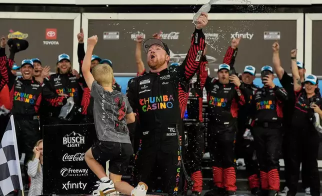 Tyler Reddick, (45) and his son Beau celebrate with the team after winning the NASCAR Daytona 500 auto race at Daytona International Speedway, Sunday, Feb. 15, 2026, in Daytona Beach, Fla. (AP Photo/Mike Stewart)