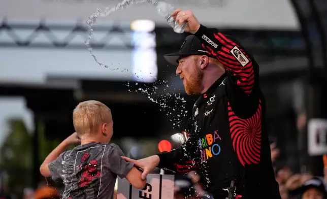 Tyler Reddick, (45) and his son Beau celebrate with the team after winning the NASCAR Daytona 500 auto race at Daytona International Speedway, Sunday, Feb. 15, 2026, in Daytona Beach, Fla. (AP Photo/Nigel Cook)