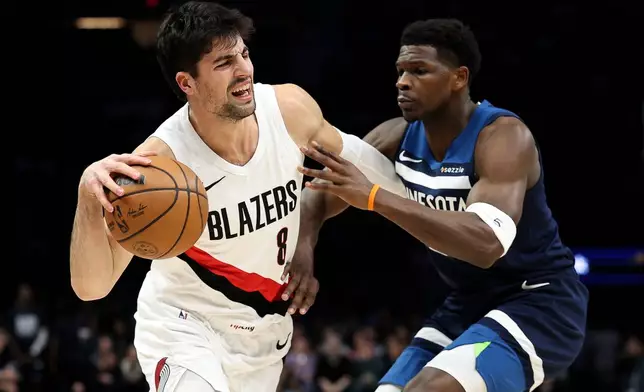 Portland Trail Blazers forward Deni Avdija, left, works around Minnesota Timberwolves guard Anthony Edwards during the first half of an NBA basketball game, Wednesday, Feb. 11, 2026, in Minneapolis. (AP Photo/Matt Krohn)