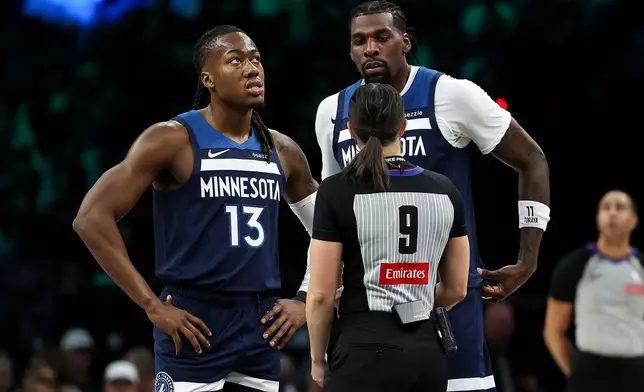 Minnesota Timberwolves guard Ayo Dosunmu, left, and center Naz Reid talk with referee Natalie Sago during the first half of an NBA basketball game against the Portland Trail Blazers, Wednesday, Feb. 11, 2026, in Minneapolis. (AP Photo/Matt Krohn)